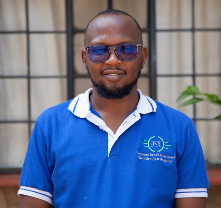 Smiling Primrose Rehab and Wellness team member in branded polo shirt at the Kiambu facility